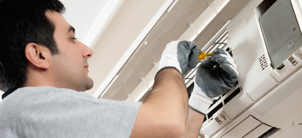 HVAC technician repairing a residential ductless AC unit