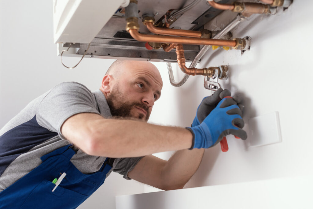Professional engineer installing a natural gas boiler at home, he is checking the pipes