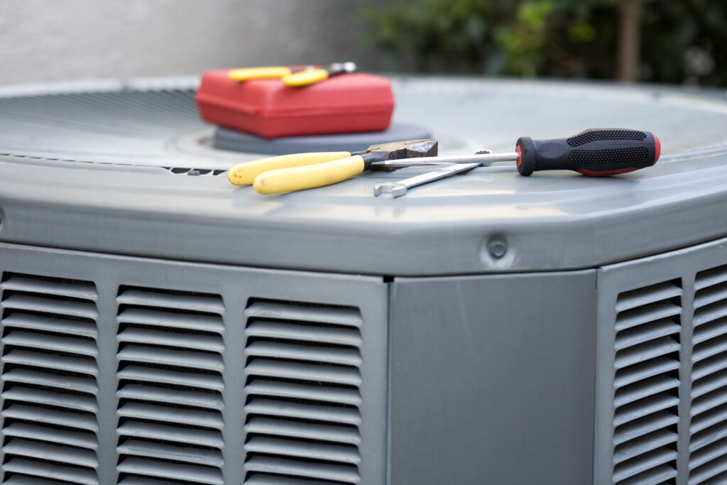 Closeup of condenser unit with tool during repair 
